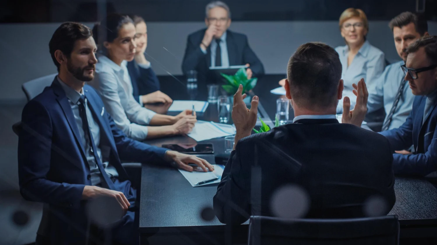 Profissionais em reunião corporativa discutindo estratégias em uma sala de conferência