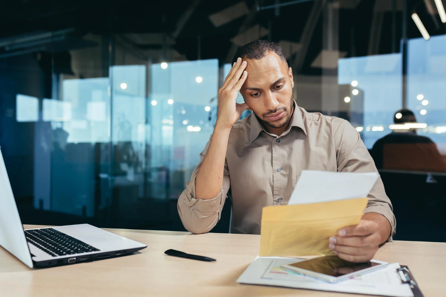 empresário preocupado analisando documentos financeiros e impostos no escritório