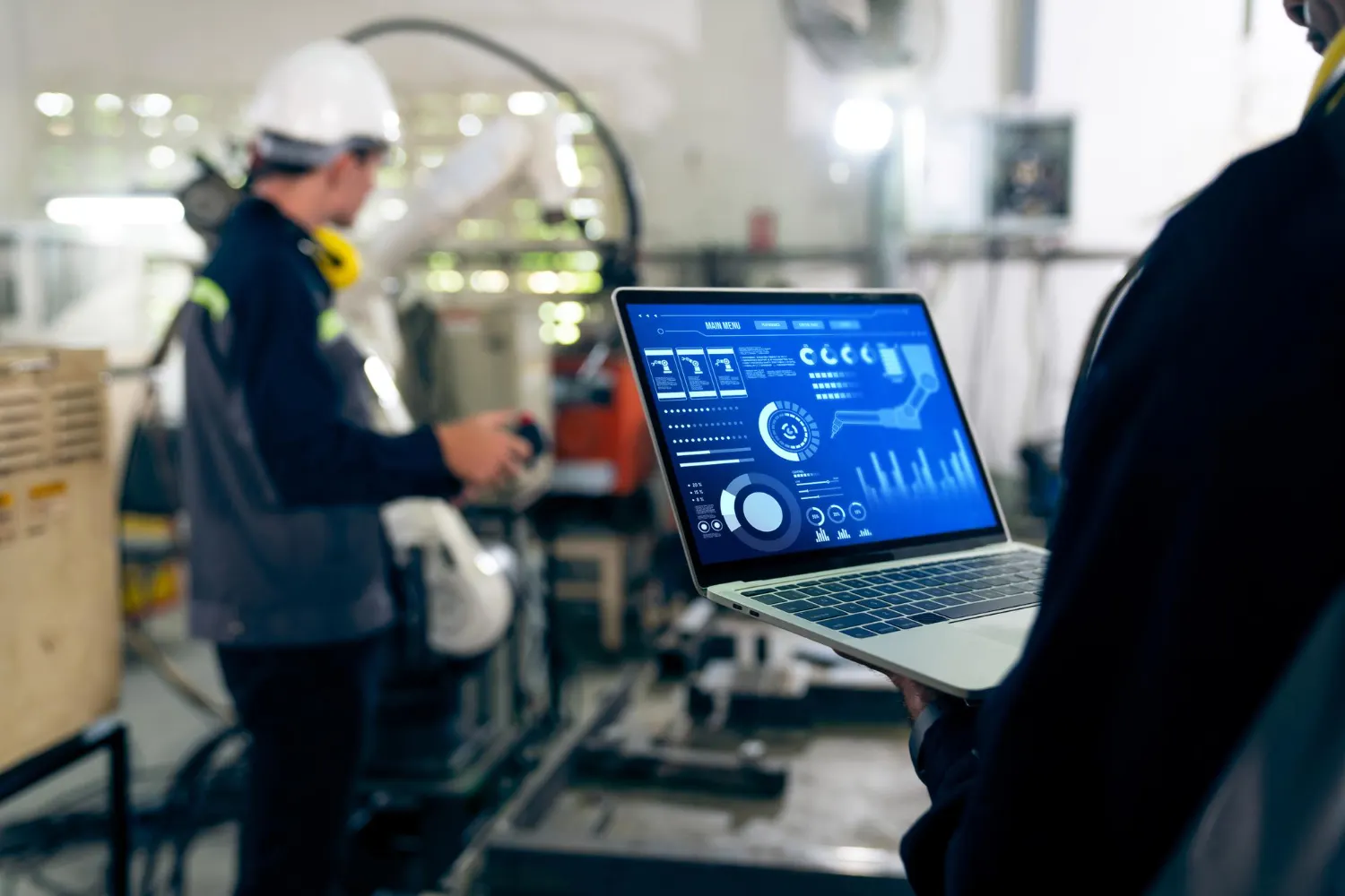 OEE e Throughput na Gestão da Produção Industrial Profissional analisando indicadores de produção em notebook enquanto acompanha operação industrial.